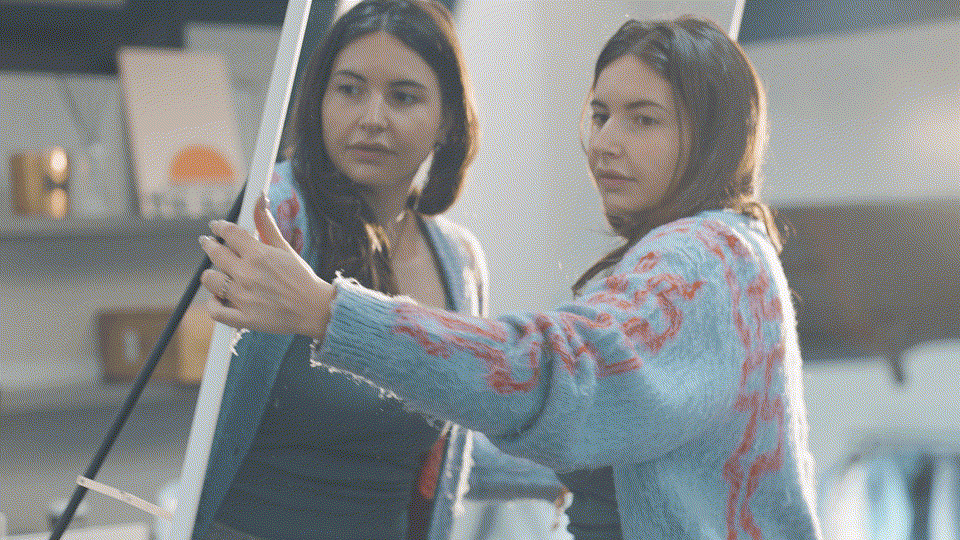 Femme portant le miroir Plumi à bout de bras après déballage