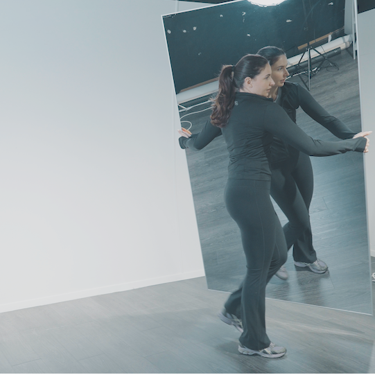 Femme déplaçant un miroir Plumi sans effort dans son studio de sport