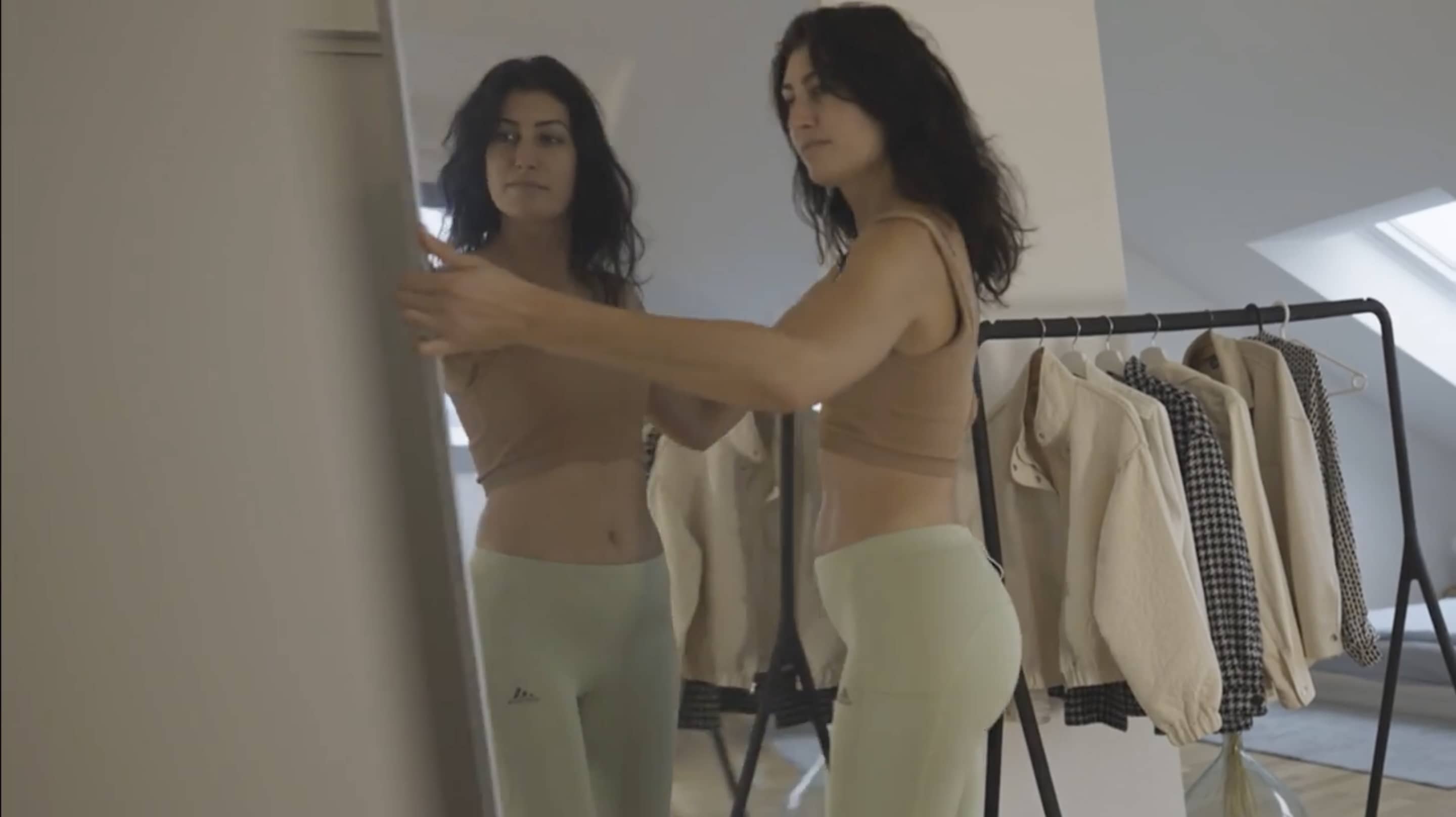 Femme en tenue de sport déplaçant un miroir Plumi ultraléger sans effort